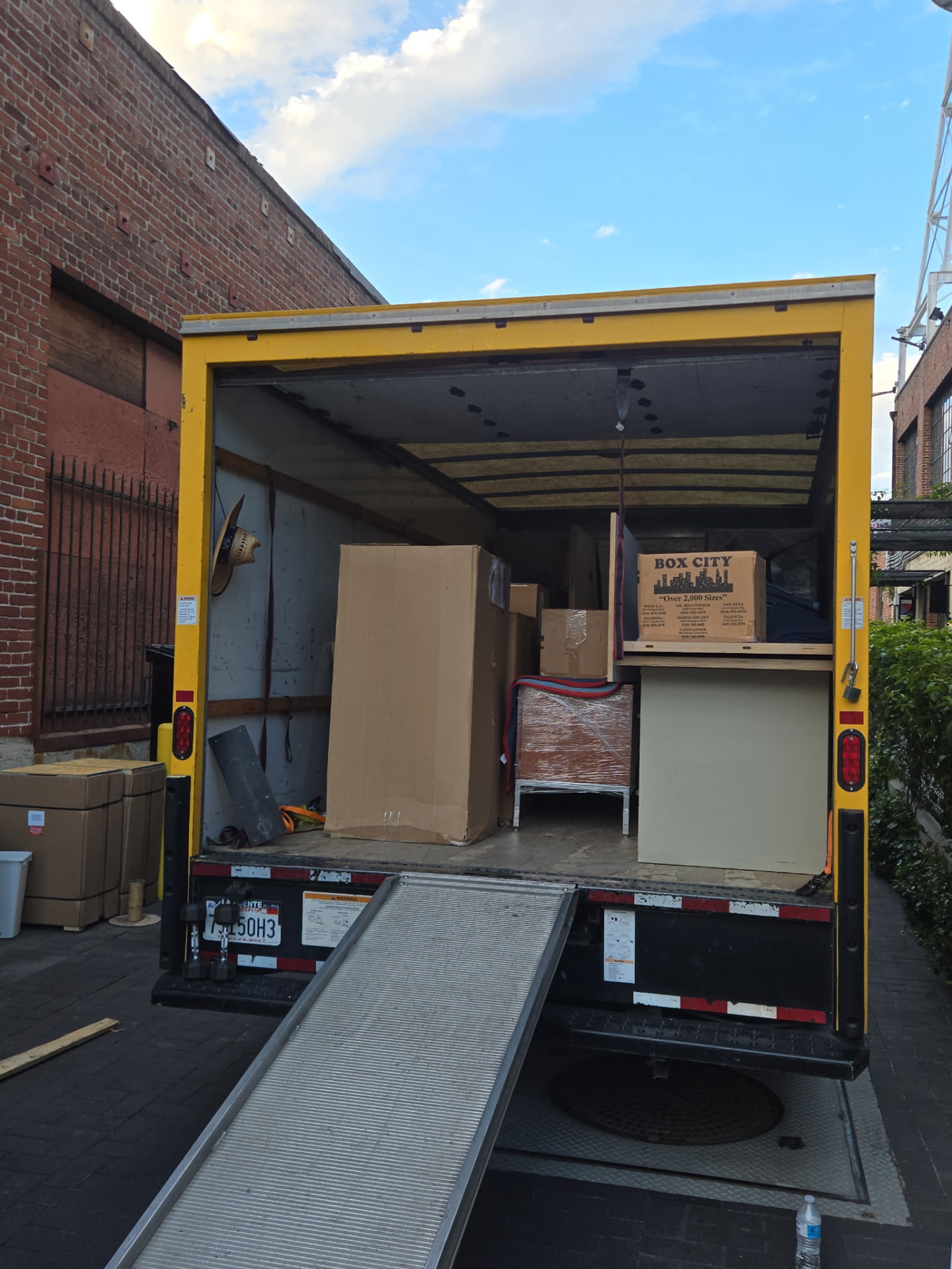 Box truck with ramp down, loaded with furniture and boxes