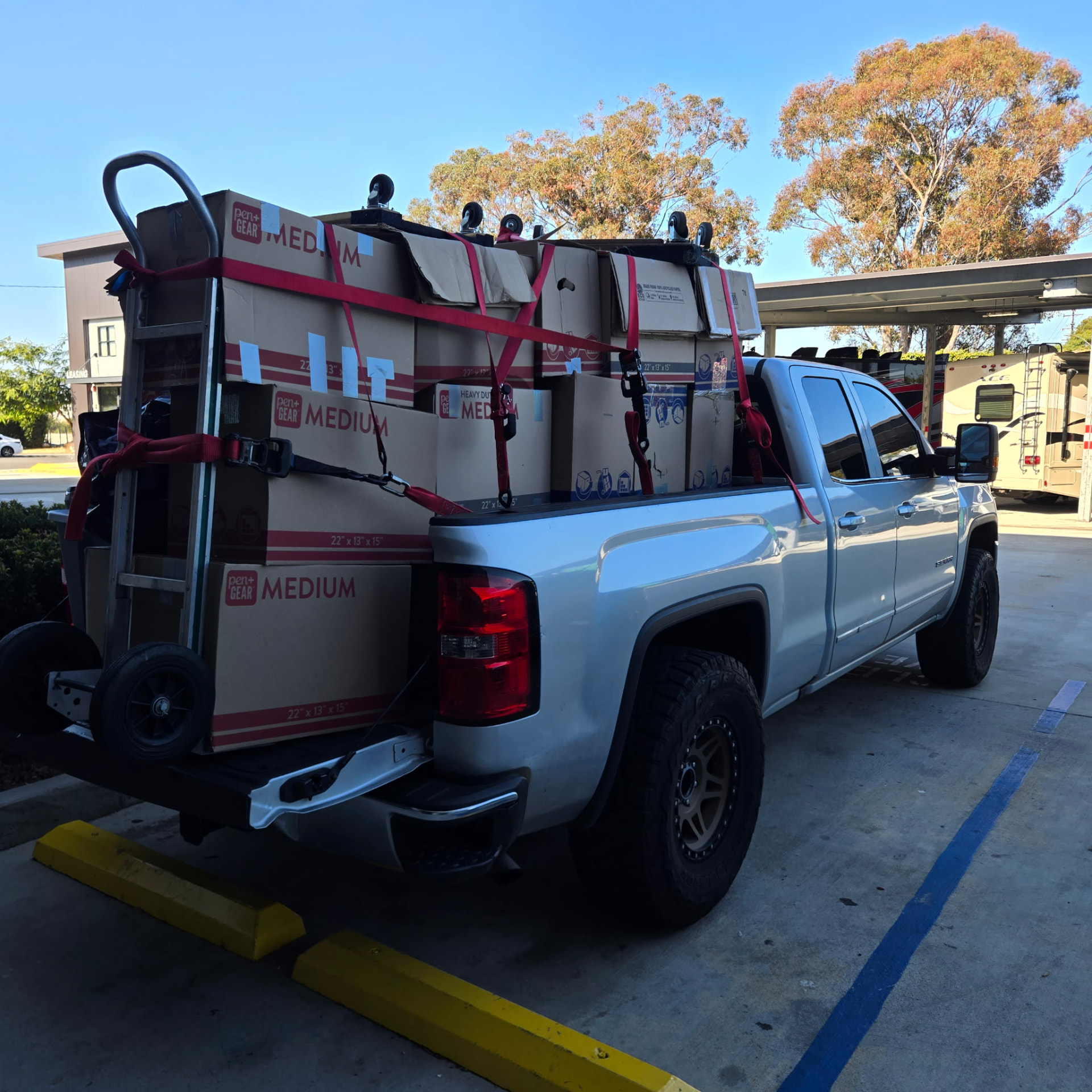 Pickup truck bed stacked and strapped with moving boxes