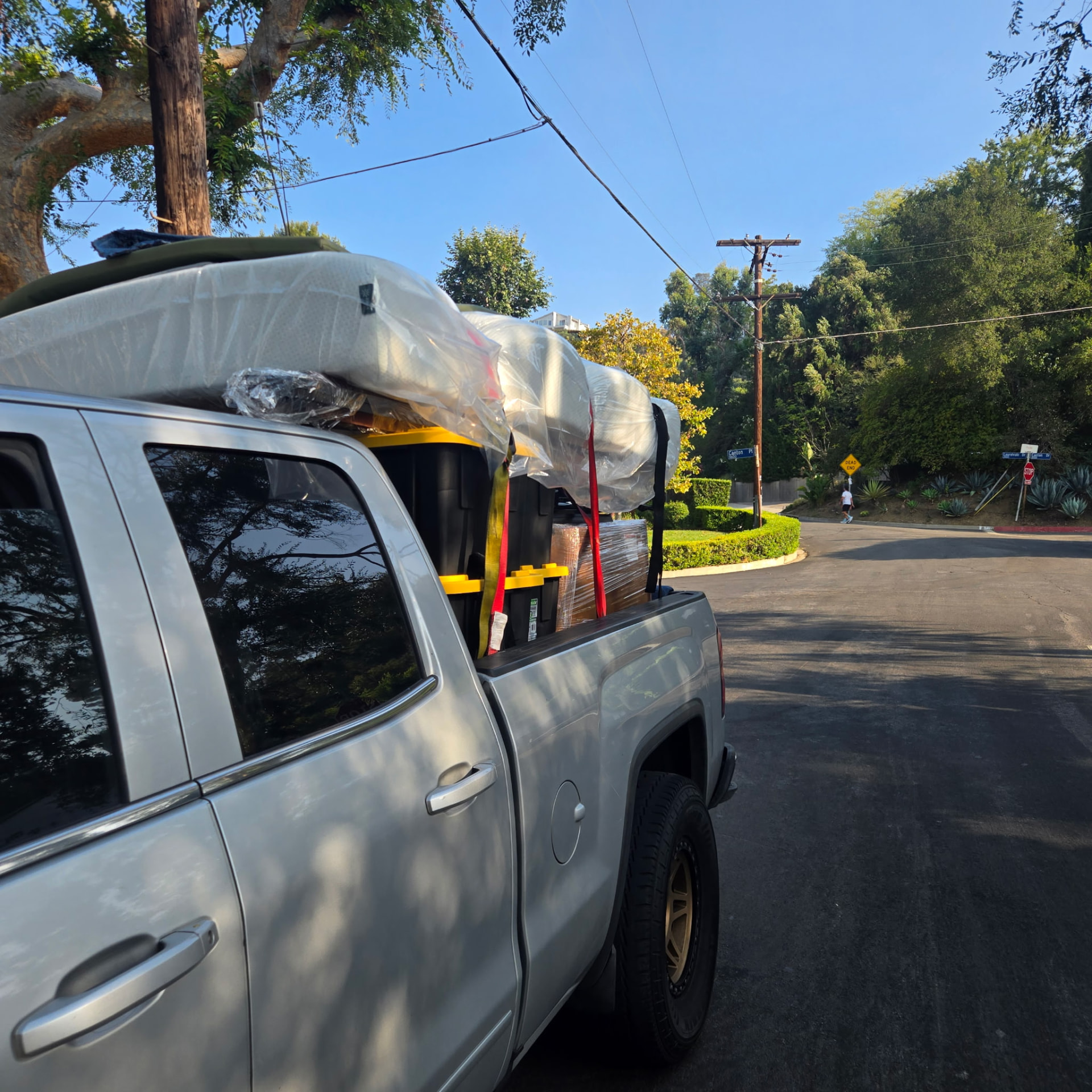 Mattresses and bins strapped to a loaded pickup truck
